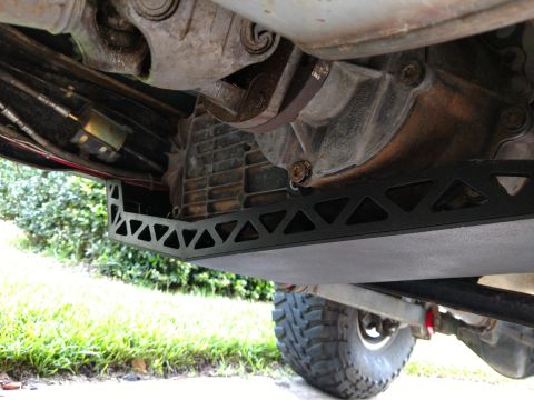 1992 Ford Bronco - Aftermarket skid plate installed under a vehicle's transfer case. Part of a tire is visible.