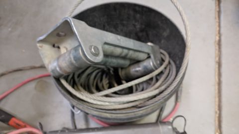 1995 Ford Bronco - A winch mechanism with a coiled cable and red electrical wire is shown in a close-up view.