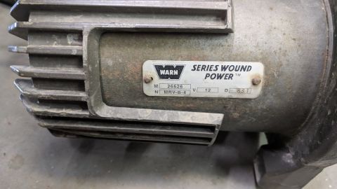 1995 Ford Bronco - Close-up of a Warn Series Wound Power motor, showing the model number MRV-B-4 and voltage rating of 12V.