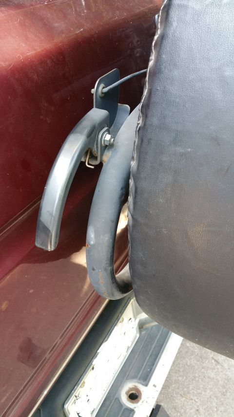 1996 Ford Bronco - Close-up of the rear tire carrier and handle on a maroon SUV.