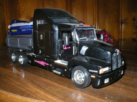 1989 Ford Crown Victoria - A black semi-truck model with pink flame decals sits on a wooden surface.