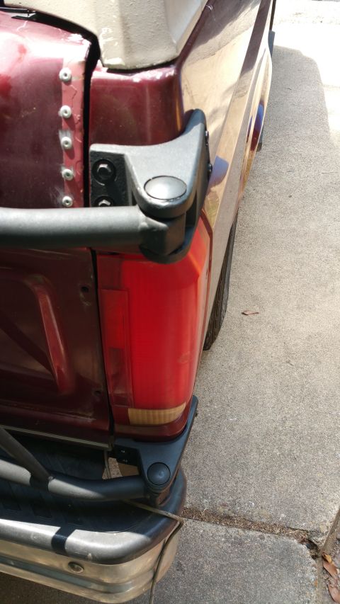 1996 Ford Bronco - Close-up of the rear passenger side of a 1996 Ford Bronco, focusing on the taillight and tire carrier.
