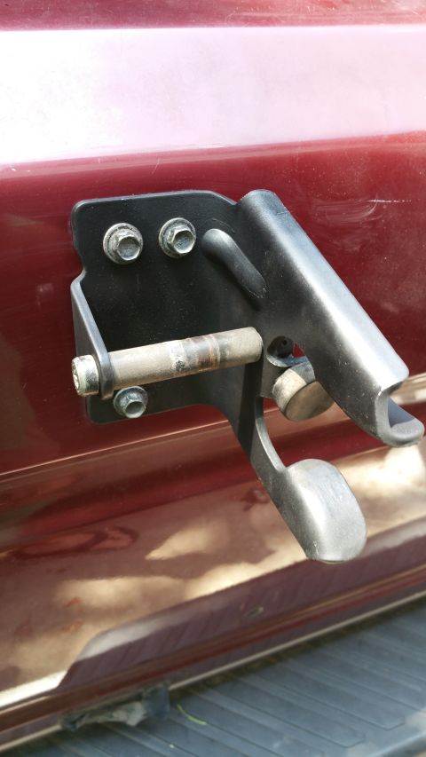 1996 Ford Bronco - This photo shows a close-up of a tire carrier mounting bracket on a red vehicle.