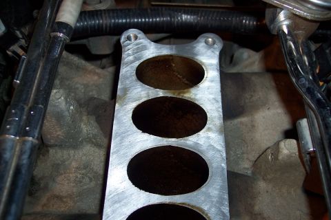 1995 Ford Bronco - Close-up of an engine intake manifold with a visible Ford logo on the engine block.