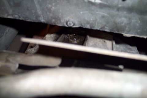 1995 Ford Bronco - Close-up of an engine bolt with oil residue visible.