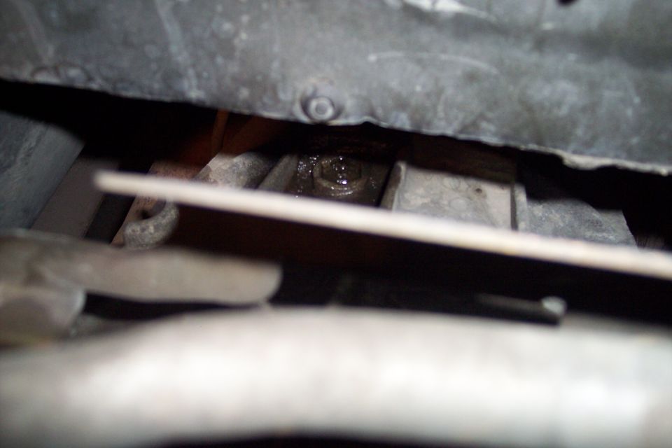 Close-up of an engine bolt with oil residue visible
