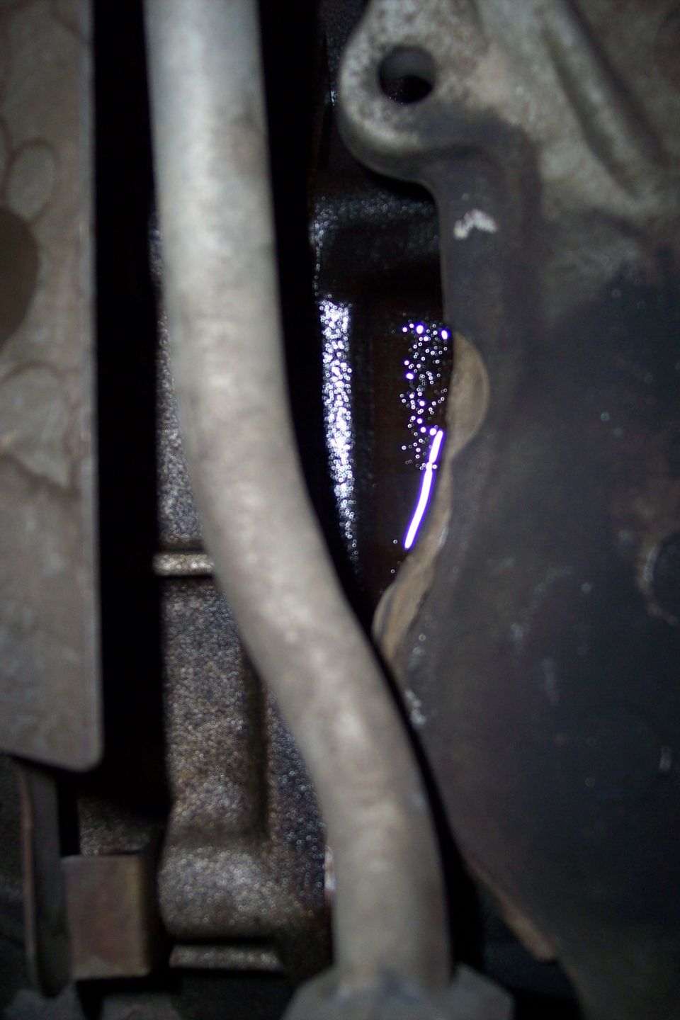 close-up of engine component with oil pooling and dripping