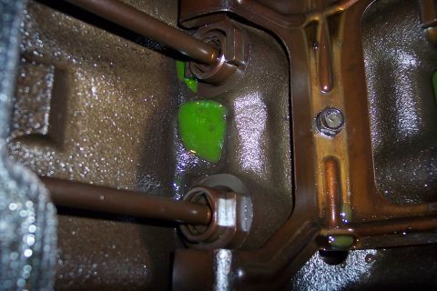 1995 Ford Bronco - Close-up of an engine block showing green coolant leaks and metal components.