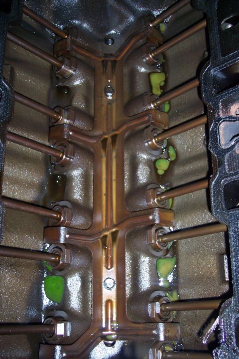 1995 Ford Bronco - Close-up view of an engine block's interior, showing pushrods and evidence of green coolant leaks.