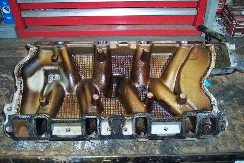 1995 Ford Bronco - Intake manifold shown on a workbench, likely removed for maintenance or repair.