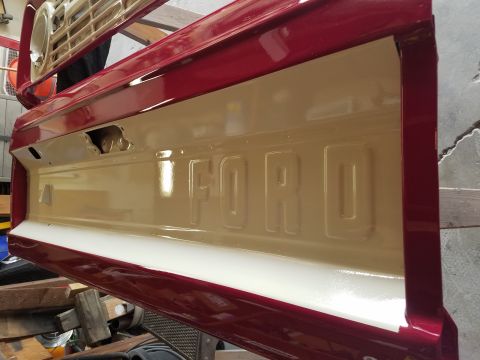 1968 Ford Bronco - A Ford tailgate is shown with embossed lettering, painted red and tan.