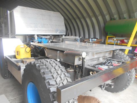 1992 Ford Bronco - This custom truck chassis features a large aluminum cargo bed and off-road tires, with a Supermotors.net logo in the corner.