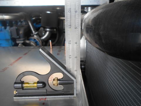 1992 Ford Bronco - A ruler and combination square are used to measure clearance in an engine bay, with a radiator visible on the right.