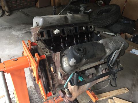 1996 Ford Bronco - A Ford V8 engine, likely from an older truck or SUV, is mounted on an engine stand in a garage setting.