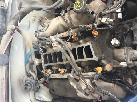 1996 Ford Bronco - Close-up view of a vehicle's engine bay, showing fuel injectors and parts of the intake system.