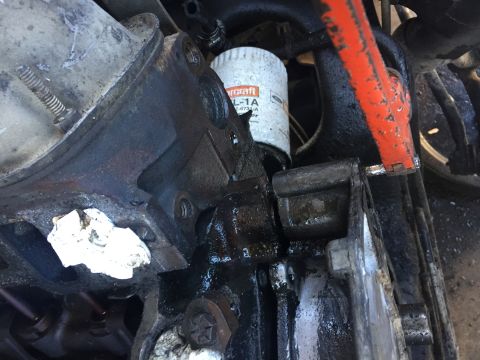 1996 Ford Bronco - Close-up view of an engine oil filter and surrounding engine components, showing oil residue.