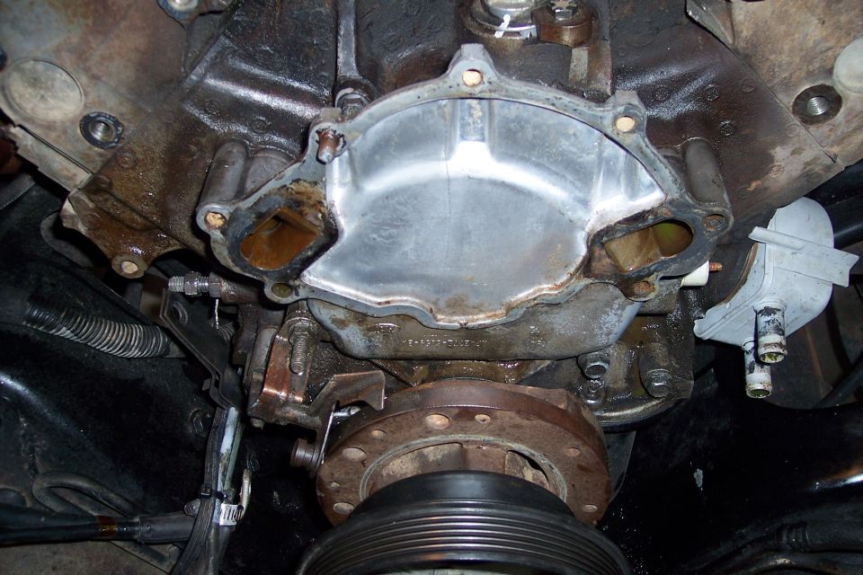 Engine block with water pump housing removed, showing gasket surface and mounting bolts