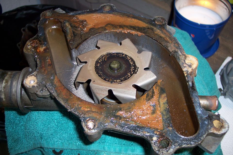Close-up of a corroded vehicle water pump with a damaged impeller