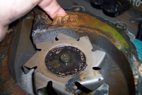 1995 Ford Bronco - Close-up of a corroded water pump impeller, showing significant rust and buildup around the edges.