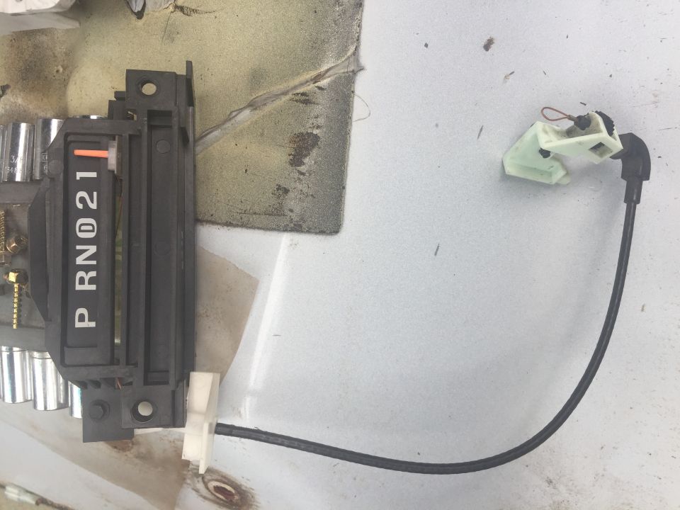 Automatic transmission shifter indicator showing P, R, N, 0, 2, 1. A small white plastic connector is attached