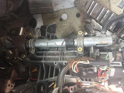 1996 Ford Bronco - Disassembled steering column components with visible wiring and metal parts.