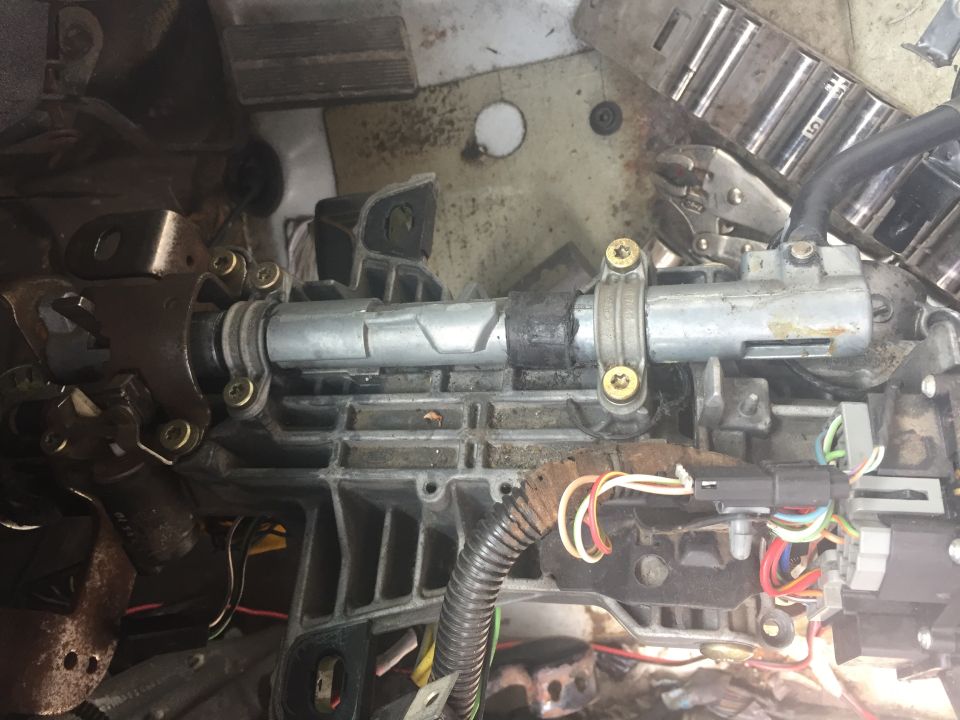 Close-up of disassembled steering column with wiring and metal components
