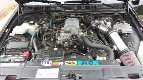 2005 Mercury Grand Marquis - Customized engine bay a supercharger and aftermarket parts, with visible brand stickers.