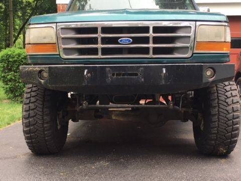 1996 Ford Bronco - Front view of a green 1996 Ford Bronco, its distinctive grille and an aftermarket bumper.