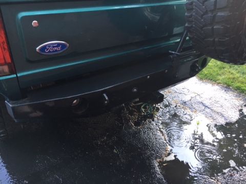 1996 Ford Bronco - Rear view of a green 1996 Ford Bronco, its bumper, spare tire mount, and Ford badging.