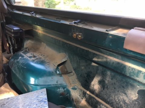 1996 Ford Bronco - This photo shows the interior of a vehicle's cargo area, focusing on the wheel well and mounting points.