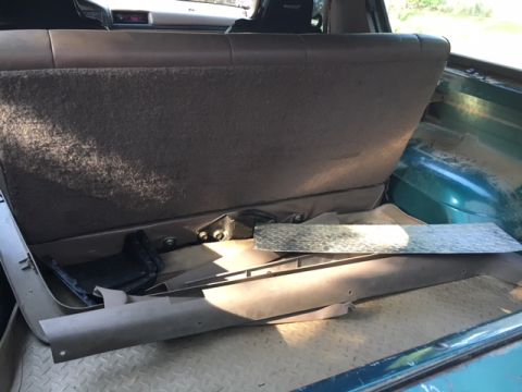 1996 Ford Bronco - The interior cargo area of a 1996 Ford Bronco shows the folded rear seat and various trim pieces.