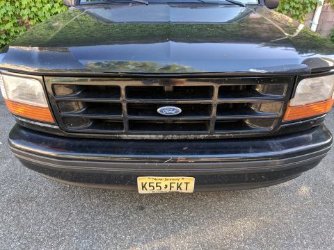 1995 Ford Bronco - Front view of a black 1995 Ford Bronco, showing the grille and license plate.