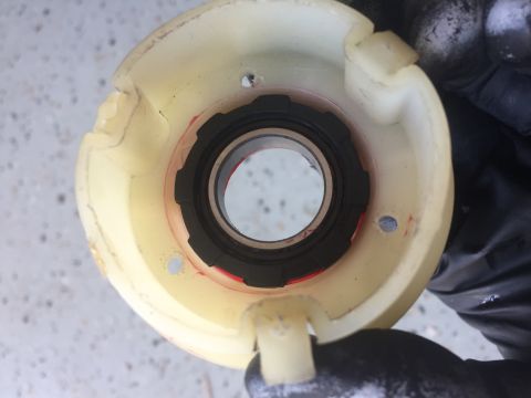 1978 Ford Bronco - Close-up of a bearing housing with a black seal, showing red markings and held by a gloved hand.