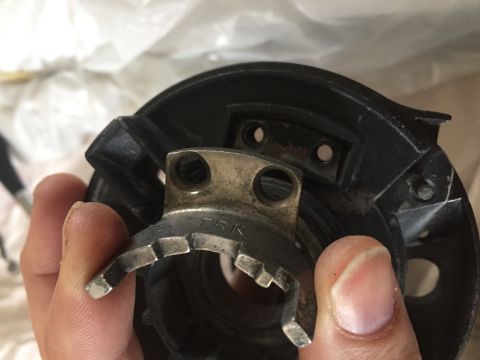 1978 Ford Bronco - A hand holds a metal and plastic component, possibly from a vehicle's engine bay.