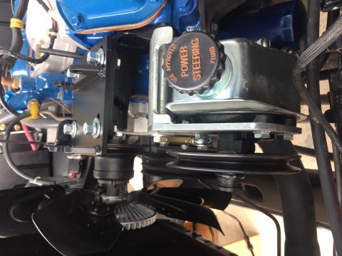 1978 Ford Bronco - Close-up of an engine bay, focusing on the power steering fluid reservoir and fan.