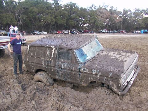 1991 Ford Bronco - This 1978 Ford Bronco is deeply stuck in a mud pit, with a person observing the scene.