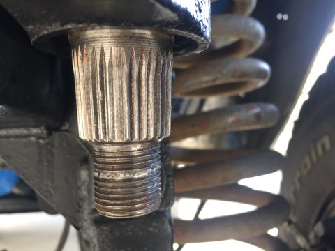 1978 Ford Bronco - Close-up view of a splined shaft and a coil spring, likely from a vehicle's suspension system.