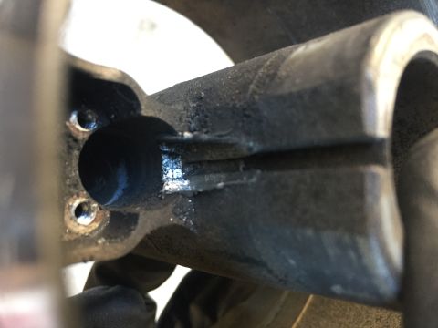 1978 Ford Bronco - A close-up view of a worn metal steering part, likely from a vehicle's steering system.