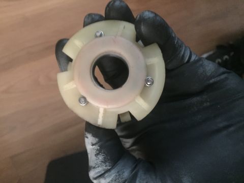 1978 Ford Bronco - A gloved hand holds a white plastic part with a metal ring and screws, likely a steering column component.