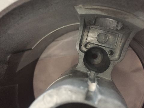 1978 Ford Bronco - A metal steering column part is shown in a close-up view, with a coin visible inside a recess.