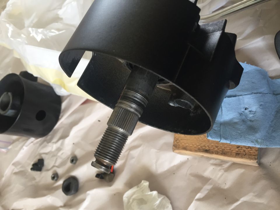 Steering column housing and splined shaft, with small parts scattered on paper