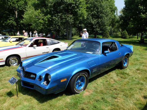 1971 Ford Ranchero - A blue Chevrolet Camaro Z28 is displayed on a sunny day at an outdoor car show.