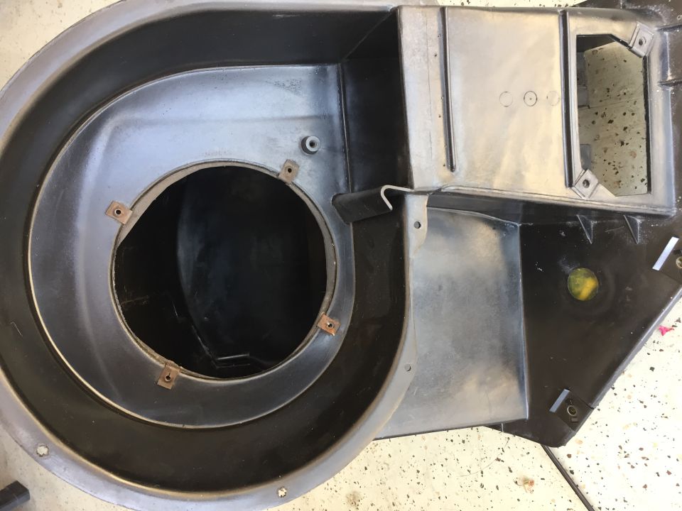 Black plastic HVAC blower motor housing with circular opening and mounting points