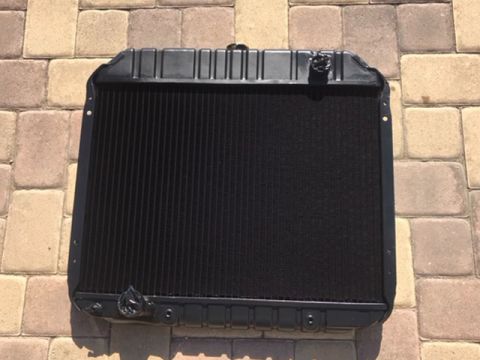 1978 Ford Bronco - A black radiator, likely for a classic vehicle, is displayed on a brick patio.
