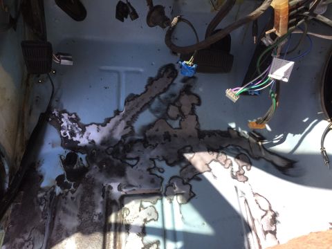 1978 Ford Bronco - Floor pan shows significant rust damage and exposed wiring. No year is visible.