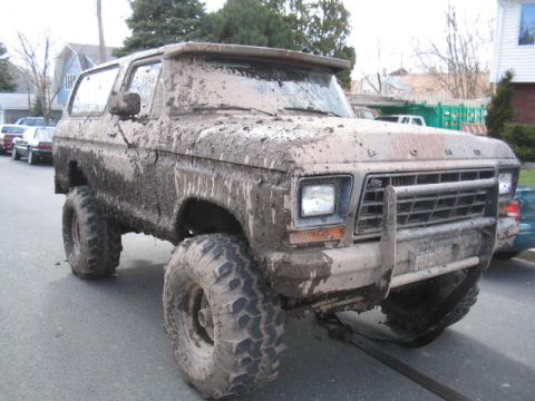 1979 Ford Bronco - Mud-caked 1978 Ford Bronco after off-roading, parked on a residential street.