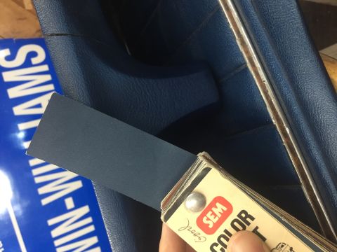 1978 Ford Bronco - SEM color swatch held against blue interior trim panel. Text visible on blue surface.
