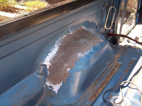 1990 Ford Bronco - The interior of a vehicle shows areas of rust and repair work on the wheel well.