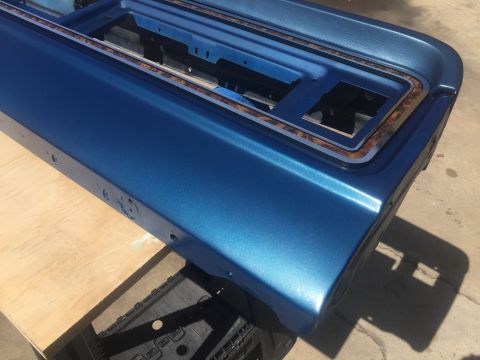 1978 Ford Bronco - A close-up view of a blue vehicle door panel, woodgrain trim and a metallic finish.