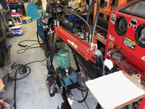 1992 Jeep Wrangler - Workshop scene with welding equipment and a hydraulic lift, no vehicle visible.